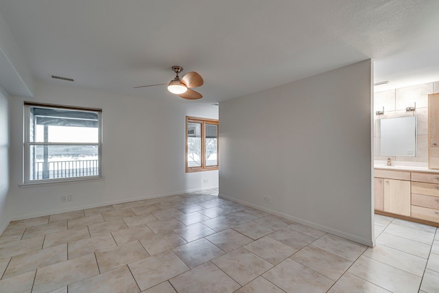 tiled spare room with ceiling fan