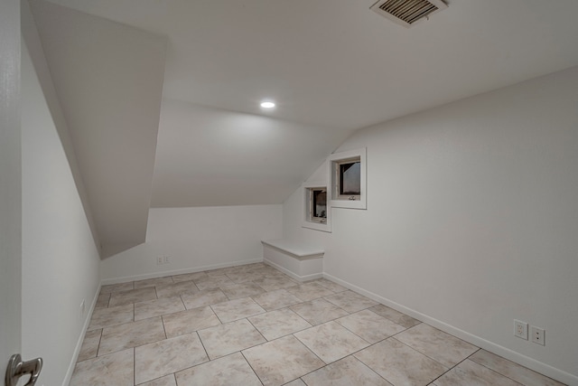 bonus room featuring light tile patterned floors and vaulted ceiling