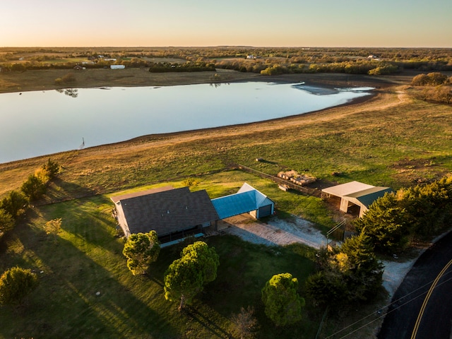 aerial view at dusk featuring a water view