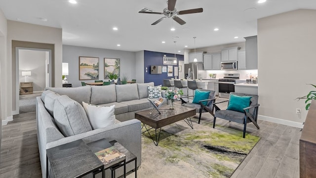 living room with ceiling fan and light wood-type flooring