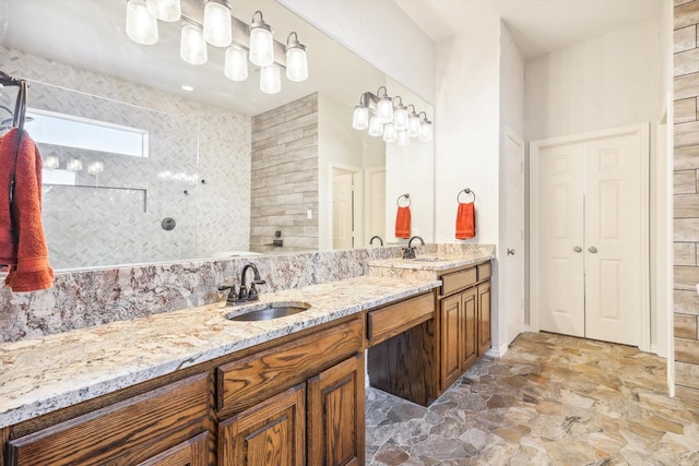 bathroom with a tile shower and vanity