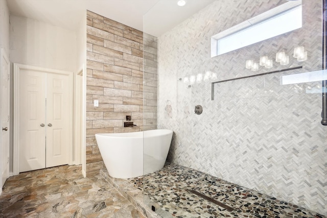 bathroom with shower with separate bathtub and tile walls