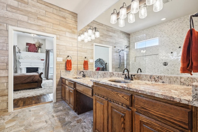 bathroom featuring hardwood / wood-style floors, vanity, tiled shower, and tile walls