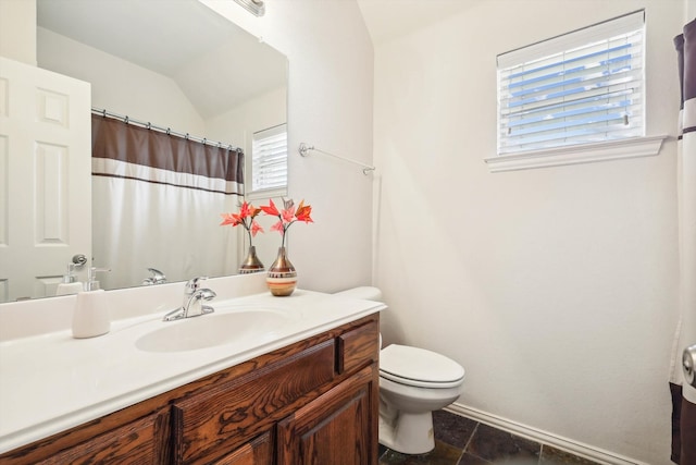 bathroom with tile patterned floors, vanity, vaulted ceiling, and toilet