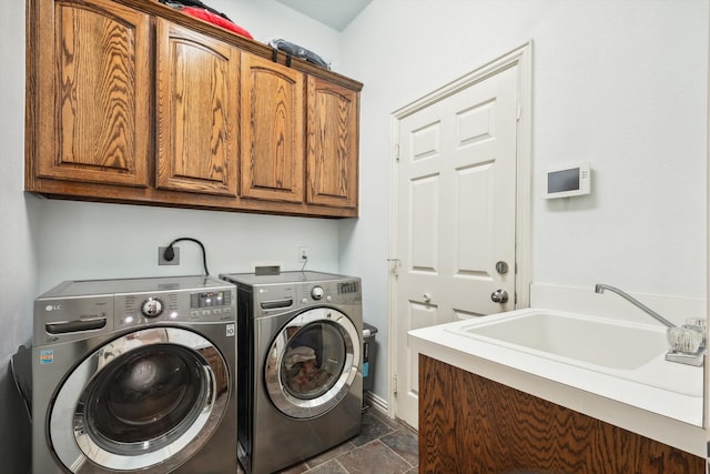 laundry area featuring cabinets, separate washer and dryer, and sink