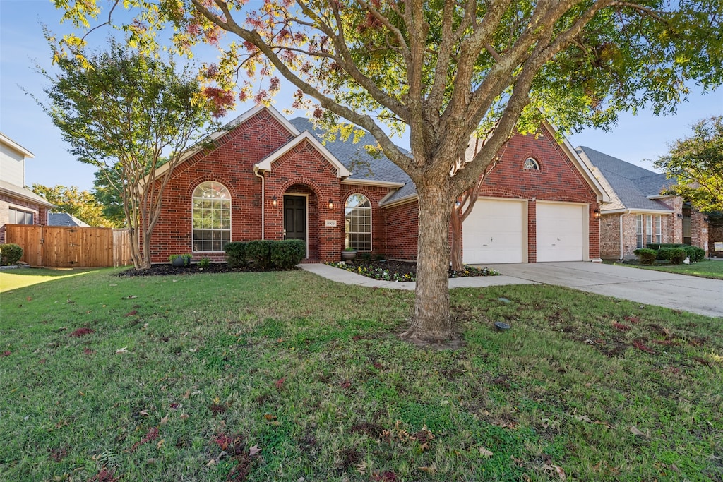 single story home featuring a front lawn and a garage