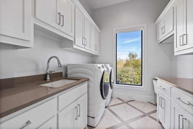 laundry room featuring washer and dryer, cabinets, and sink