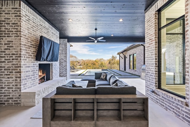 view of patio / terrace featuring an outdoor living space with a fireplace and ceiling fan