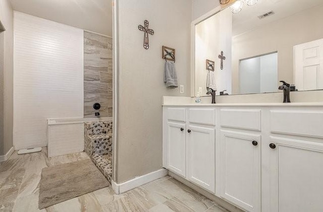 bathroom featuring vanity and tiled shower