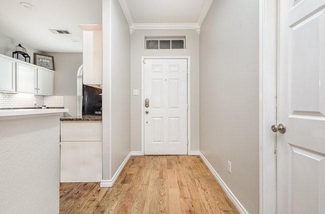 doorway to outside featuring crown molding and light hardwood / wood-style flooring