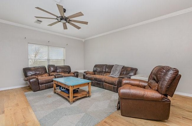 living room with wood-type flooring, ornamental molding, and ceiling fan