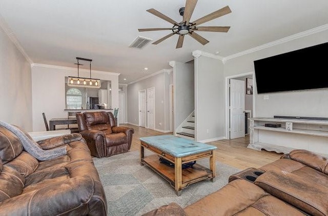 living room featuring ceiling fan, crown molding, and light wood-type flooring