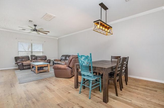 dining area with ceiling fan with notable chandelier, ornamental molding, and light hardwood / wood-style floors