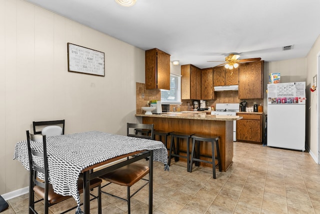 dining room featuring ceiling fan and sink