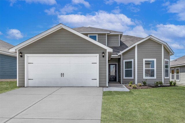 view of front of home featuring a front yard and a garage