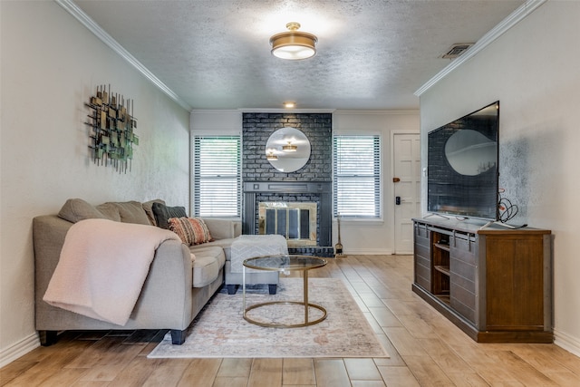 living room with crown molding, plenty of natural light, light hardwood / wood-style floors, and a textured ceiling