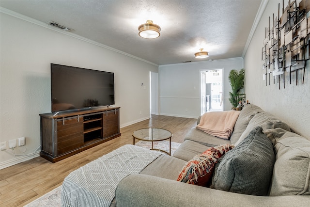 living room featuring crown molding, light hardwood / wood-style floors, and a textured ceiling