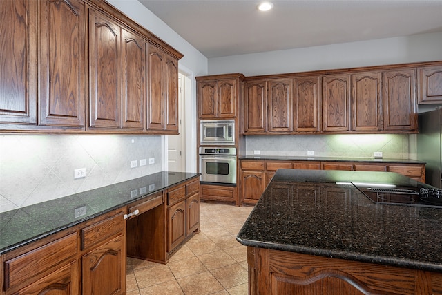 kitchen featuring dark stone countertops, appliances with stainless steel finishes, and tasteful backsplash