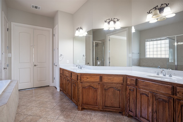 bathroom featuring tile patterned flooring, vanity, an inviting chandelier, and independent shower and bath