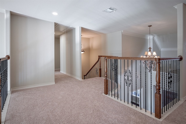 hall featuring light colored carpet, crown molding, and a chandelier