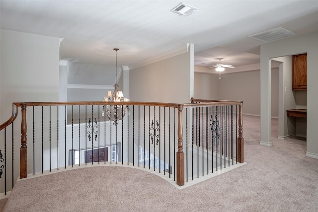 hall with crown molding, light colored carpet, and an inviting chandelier