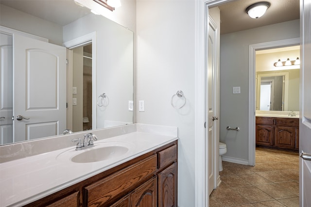 bathroom featuring tile patterned flooring, vanity, and toilet