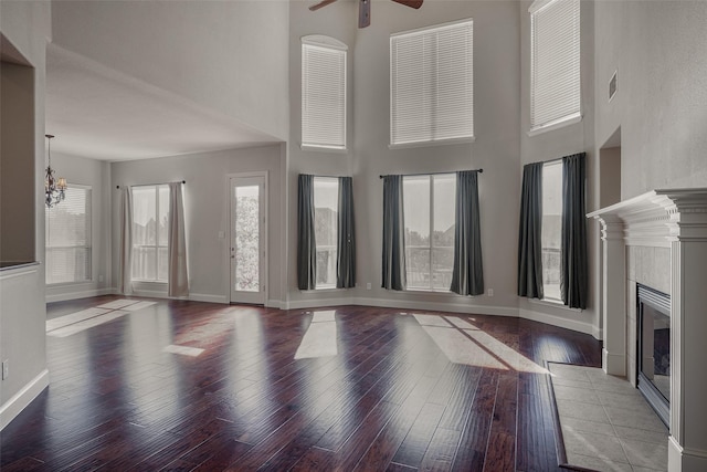 4844 Exposition Way, Fort Worth, TX 76244 - unfurnished living room with ceiling fan, a high ceiling, wood-type flooring, baseboards, and a chandelier