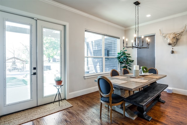 dining area featuring an inviting chandelier, crown molding, and dark hardwood / wood-style flooring