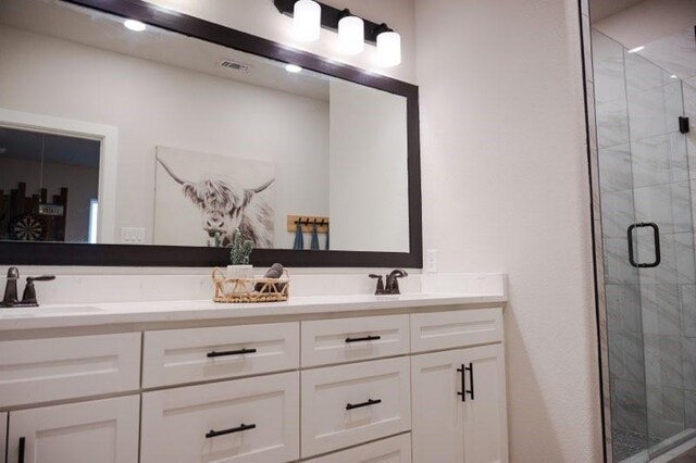 bathroom featuring a shower with door and vanity