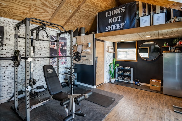 exercise room featuring hardwood / wood-style floors and lofted ceiling