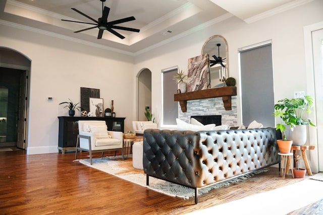 living room with ceiling fan, crown molding, hardwood / wood-style floors, and a tray ceiling