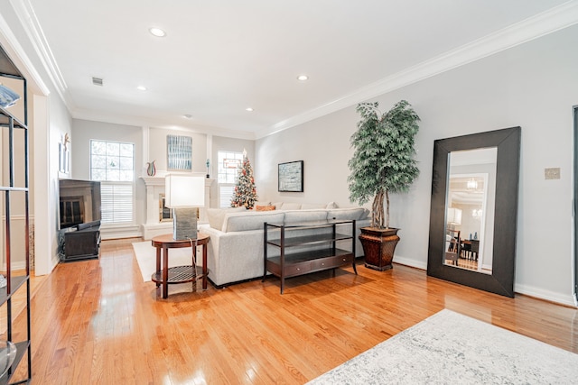 living room with light hardwood / wood-style flooring and ornamental molding