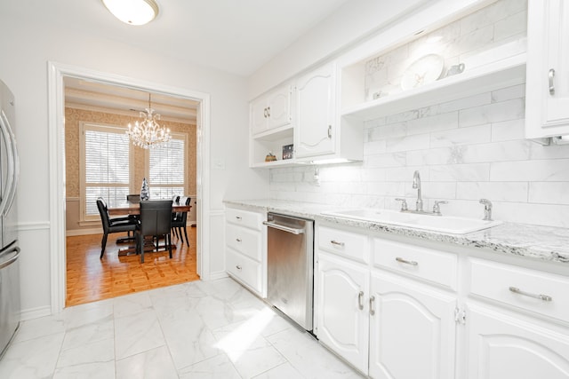 kitchen with stainless steel dishwasher, sink, decorative light fixtures, an inviting chandelier, and white cabinetry