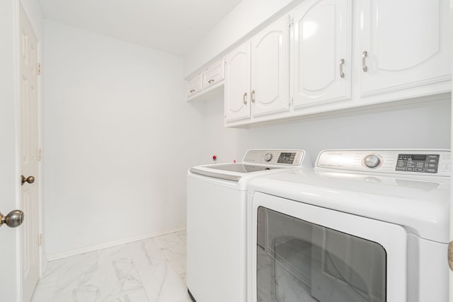 laundry room featuring washing machine and dryer, marble finish floor, cabinet space, and baseboards