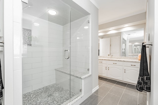 full bathroom with ornamental molding, tile patterned flooring, a shower stall, and vanity