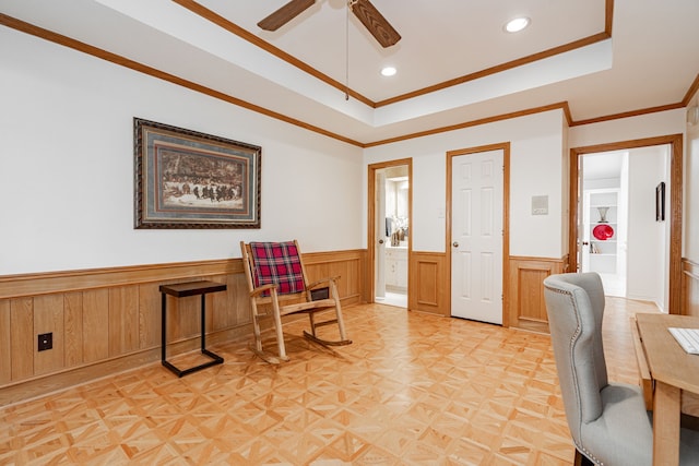 office space with recessed lighting, a raised ceiling, ornamental molding, a ceiling fan, and wainscoting