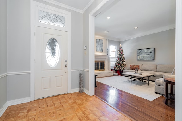 entryway with crown molding and light parquet flooring