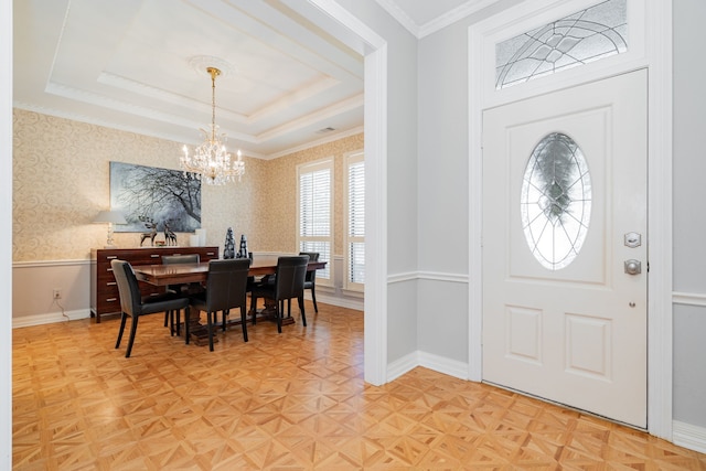 interior space with a raised ceiling, parquet floors, and a notable chandelier