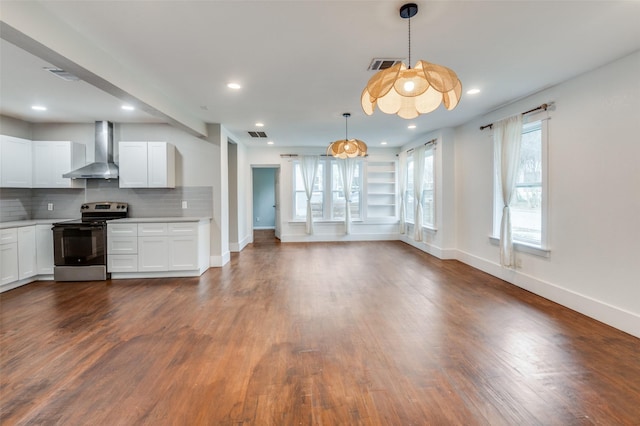 kitchen featuring decorative light fixtures, backsplash, white cabinets, stainless steel range with electric cooktop, and wall chimney exhaust hood