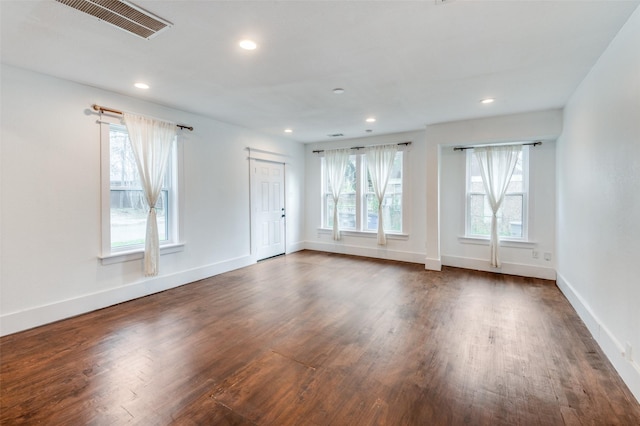 spare room featuring dark wood finished floors, visible vents, and recessed lighting