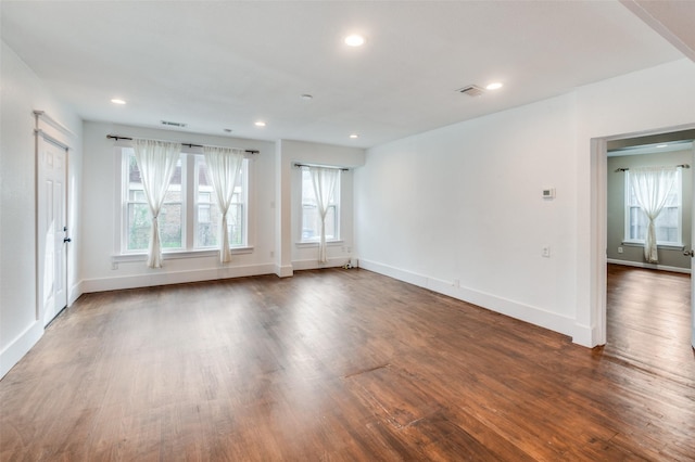 unfurnished room featuring recessed lighting, dark wood-style flooring, visible vents, and a healthy amount of sunlight