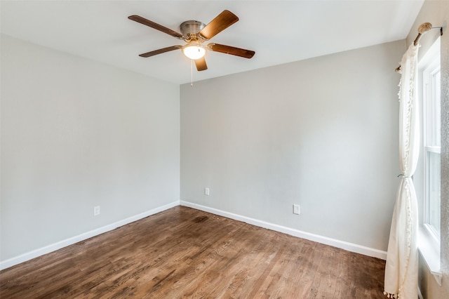 empty room featuring ceiling fan, baseboards, and wood finished floors