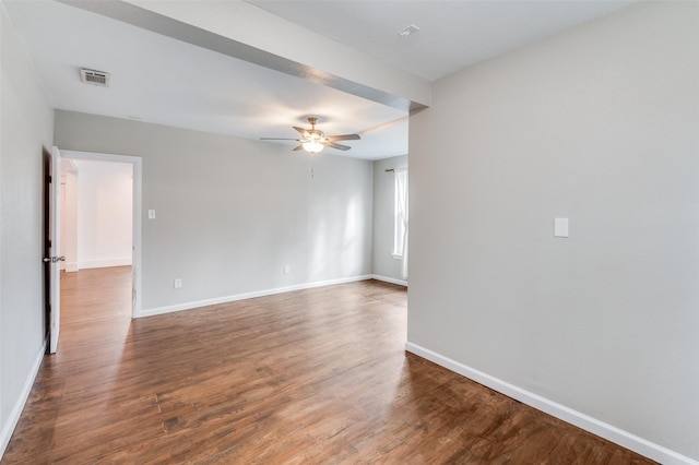 empty room featuring baseboards, visible vents, ceiling fan, and wood finished floors