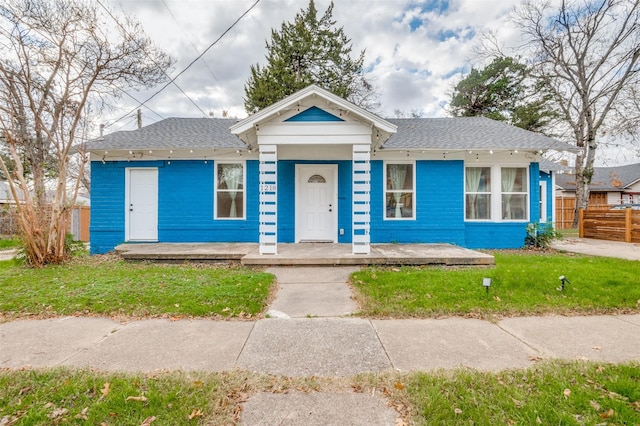 view of front of house with covered porch and a front lawn