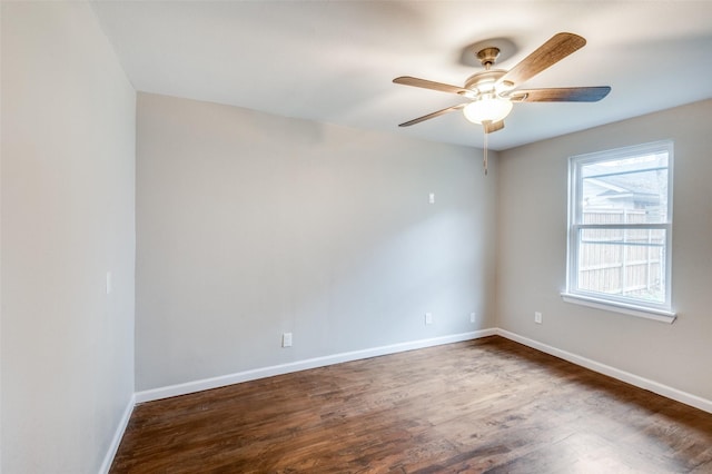 spare room featuring a ceiling fan, baseboards, and dark wood-type flooring