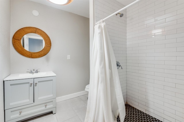 full bathroom with a stall shower, vanity, baseboards, and tile patterned floors