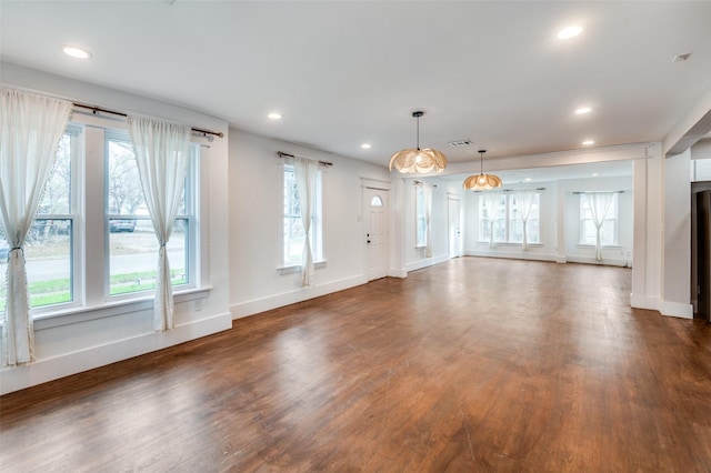 unfurnished living room featuring dark wood-style floors, baseboards, visible vents, and recessed lighting