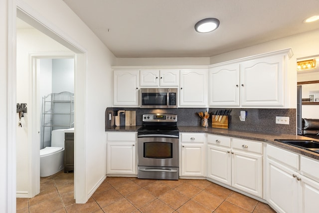 kitchen featuring white cabinets, appliances with stainless steel finishes, and backsplash