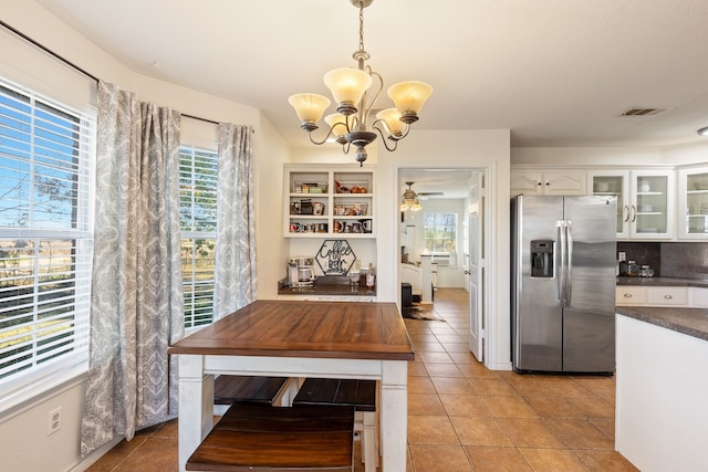 dining room featuring ceiling fan with notable chandelier and light tile patterned flooring