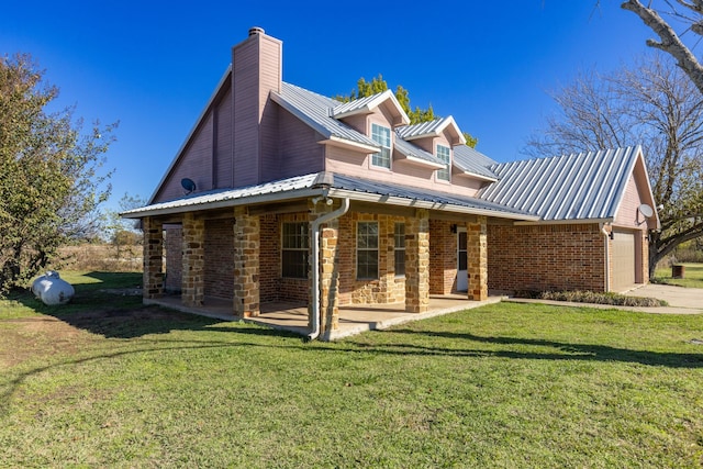 rear view of house with a lawn and a garage